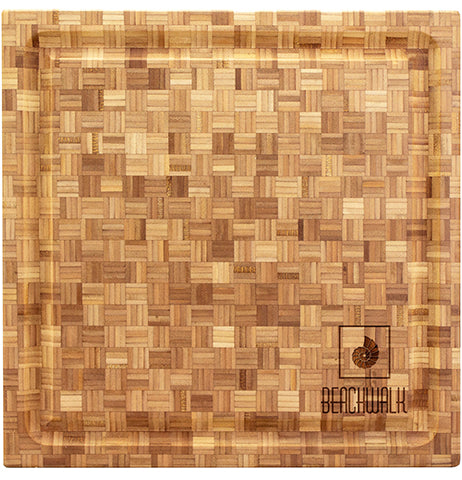 A wooden cutting board with a logo engraved in the right hand bottom corner.