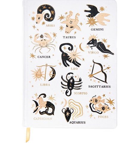 A white journal with black, gold, and yellow astrology designs on it.