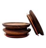 A stack of two wooden lids. Another lid is leaning against the stack.
