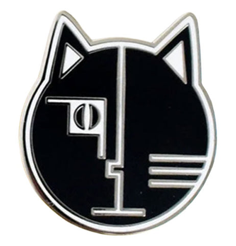 black cat pin with a white border, has a white line dividing the face where the bottom comes to a line like a mouth and their is a indent above that forming a nose. one cat eye is on the middle left in a square like pattern and lines to show whiskers are on the bottom right each ear also has a white triangle.