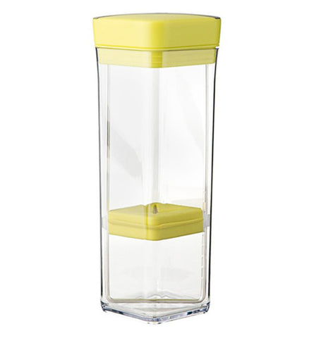 This rectangular glass storage container has a yellow lid at the top and a yellow holder near the glass bottom.