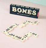 The black box is shown with its bone shaped domino contents on a table.