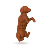 Close up view of red dog shaped tea infuser with steeping holes in the middle over a white background.