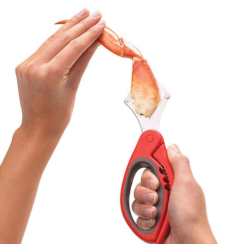 The silvery metal pliers are extracting the meat from inside the crab's leg. 