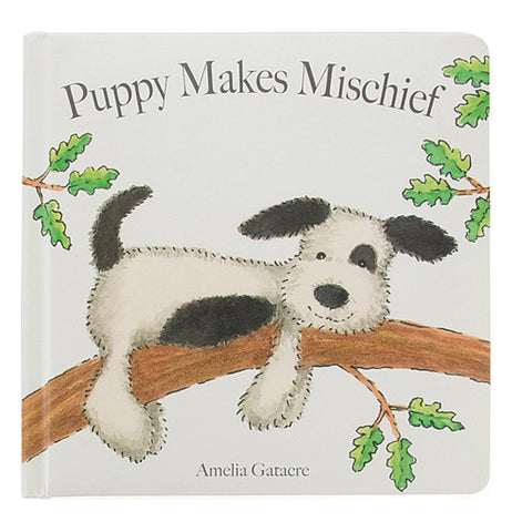 A white book cover with a black and white spotted puppy laying on a tree branch with the title "Puppy Makes Mischief" above