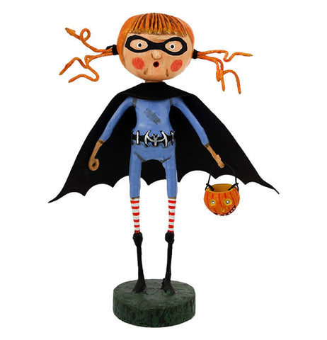 This figurine is of a little girl wearing a blue suit with a black bat wing shaped cape and holding A Jack-O-Lantern basket.