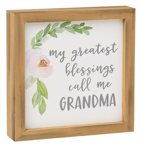 White framed box sign with a green and pink flower drawing that says My Greatest Blessings call me Grandma.