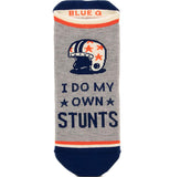 football themed sock with a gray background, with blue soles and toes and orange and white stripes on the boarder of the gray. the words "I do my own stunts" are directly under a white and blue football helmet with orange stars