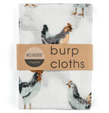 These white burp cloths with a design of multi-colored chickens is shown within its cardboard packaging.