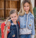 Two girls are wearing the unicorn patches on their clothes.