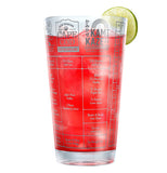Vodka drink cup filled with a red drink and a lemon or lime on the rim.