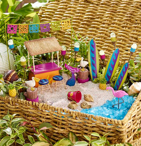 The sand pebbles are shown as the base of a miniature beach setting with blue pebbles simulating the water and a miniature food stand.