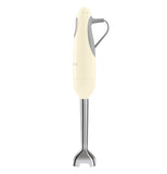 The side view of this cream colored hand blender shows on the right he grey power cable, the base part is silver.