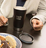 The lid sits on a black table next to a black water bottle and a plate of food