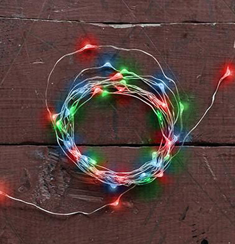 The multicolored Copper String Lights hangs outside on the wooden wall. 
