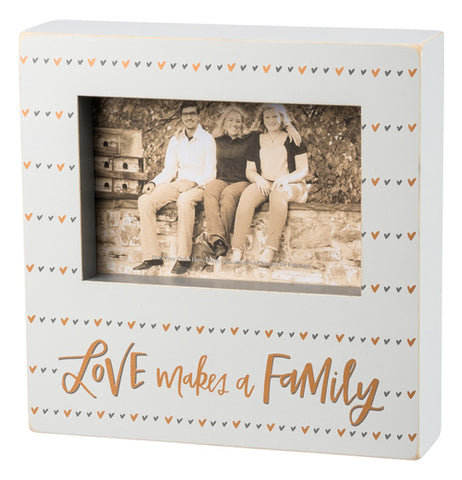 Box sign with grey and gold heart design and says "Love makes a family."