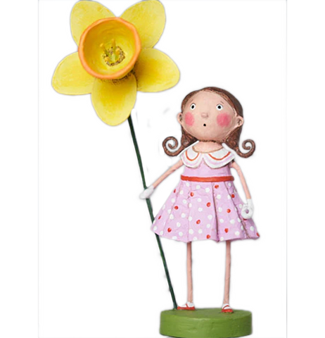 A figurine of a brown haired, rosy cheeked girl in two ponytails. She wears a red, white, and pastel pink dress, and is holding a comically large yellow flower.