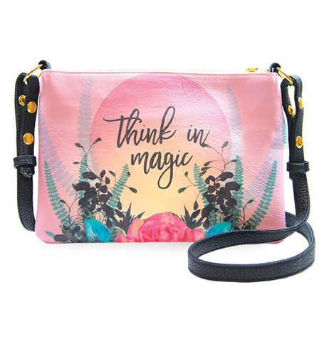 Pink hand bag with floral design that says Think in Magic. It has a black adjustable strap.