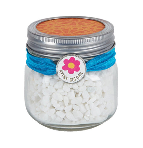 This clear jar contains white pebbles to make a small garden cover.