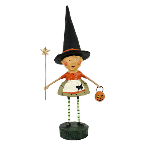 This witch figurine wears her pointed hat and holds a star-shaped wand in one hand and a pumpkin-shaped basket in the other. She wears an orange shirt and a green skirt.