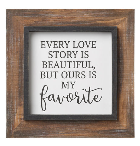 The "Favorite" Layered Sign is a sign that reads "Every Love Story is Beautiful, But Ours is My Favorite" in black over a white background surrounded by a natural wood frame. 