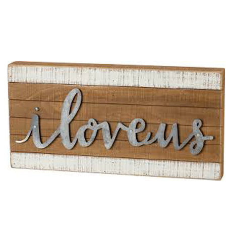 The sign "I Love Us" carved on hazel brown background in between two white-painted lines. 