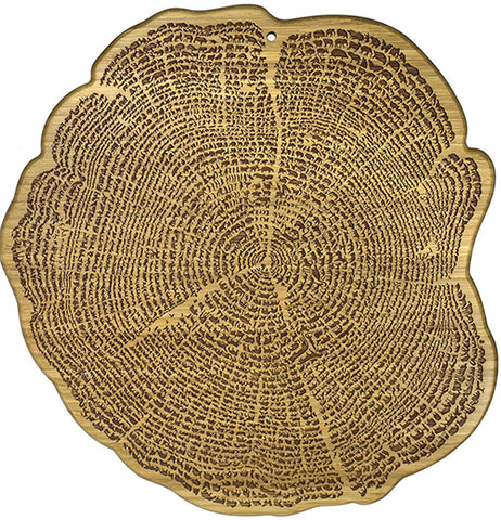 A cutting board is organically shaped like a tree stump. Animal shapes are engraved in it.