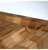 A wooden cutting board, taken from an artistic angle that shows its gassets.