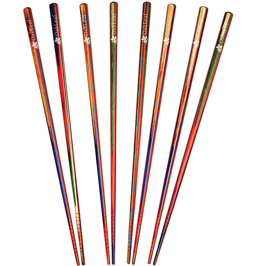 Eight multicolored bamboo chopsticks are lined up next to each other. They are mostly red, blue, green, and brown.