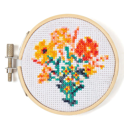bouquet of flowers in reds and oranges on a small hoop held shut by a metal bolt.