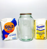 A glass jar with the Weck logo engraved on it sits between Gold Medal All Purpose Flour and Domino Granulated Sugar.