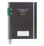 A black notebook has gray text ("standard issue notebook No. 03"), a gray elastic band to hold it closed, a gray spine with a green elastic pencil holder, three bookmarks (two gray, one black), and a white "property of" sticker.