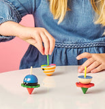Little girl spinning the tops to make them go.
