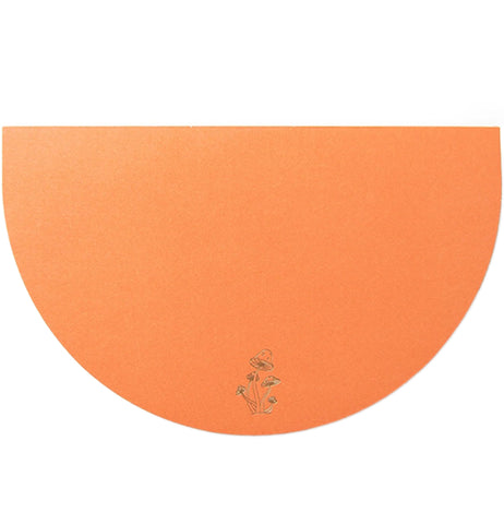 An orange, half-circular notepad has a mushroom design in the center bottom of it.