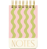 A wired pocket notebook has pastel pink and green wavy lines on it and the words "Notes" written beneath the design.