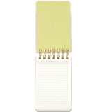 A wired pocket notebook opens vertically to reveal white lined pages and a pastel green front cover.