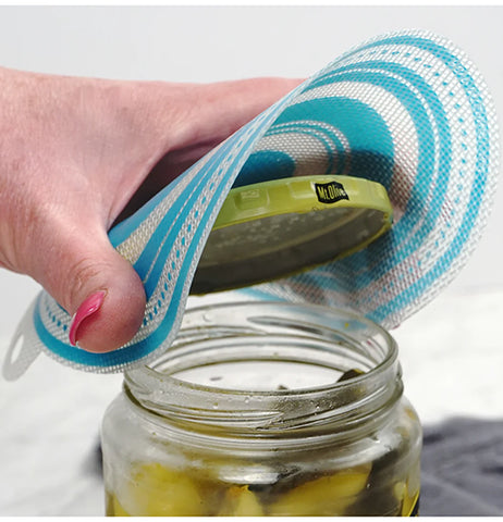A white and blue jar opener is being used by a disembodied caucasion hand to open a jar of olives.