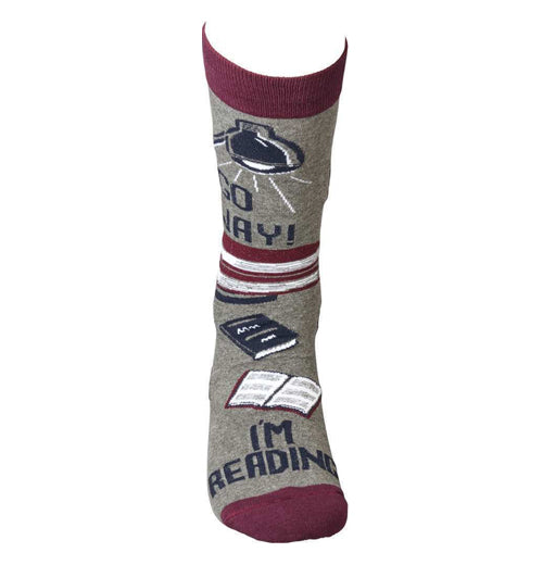 The gray sock with the red tops and toes has a design of books and desk lamps with the words, "Go Away I&