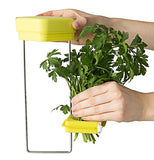 Green herbs are put in the holder in the middle of the metal frame below the yellow lid.