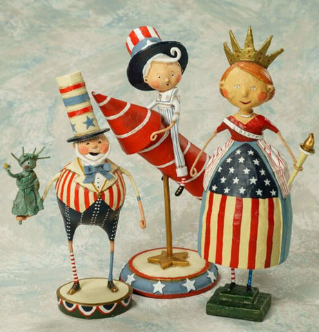 The Pete figurine is shown sitting on a table next to two other independence day figurines.