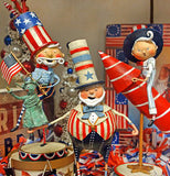 The Pete figurine is shown sitting on a shelf with some other Independence Day merchandise.