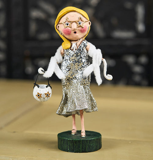 The Scarlette Starlet figurine stands on the wooden table. 