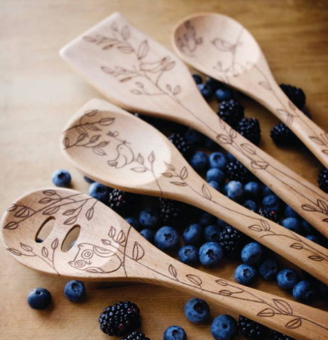 The wooden spoon with the image of a bird is shown with other wooden spoons with similar designs.