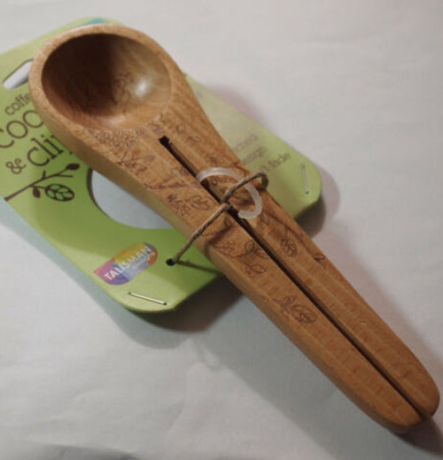 The double handled spoon with the hedgehog is shown attached to its green packaging and sitting on a table.