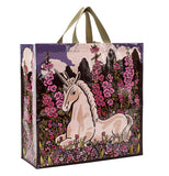 This Shopper bag shows a unicorn sitting on a field of pink and purple flowers. 