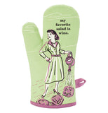 This oven mitt has a light green fabric with a woman in 1950's garb watering lettuce in purple and white details with a text in black that says, "My Favorite Salad is Wine".