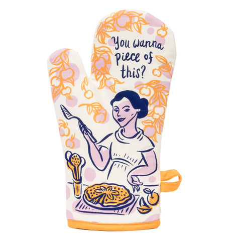 A Picture of a orange and white oven mitt with a picture of a woman holding a pie server and standing in front of a pie while saying "You Wanna Piece of This?"