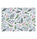 This white placemat has a design of green Christmas tree branches, red berries, and holly boughs.