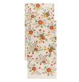 This cream colored table runner has a design of red, purple, and yellow flowers covering it.