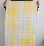 This bright lemon and white plaid dish cloth that somebody is holding up by their hands.